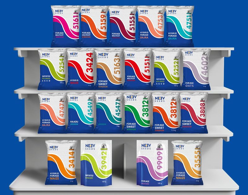 Neev Seeds forage seed packets on a shelf, each with a single colour strip