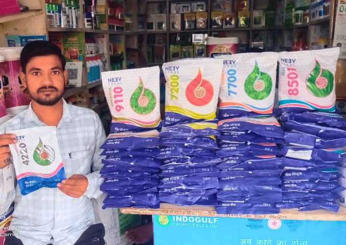 Dealer holding new Neev Seeds packets with crop-coded colour strips